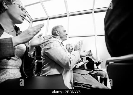 side view. smiling business seminar listeners applauding together. Stock Photo