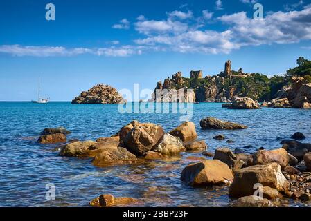 Rocky coast with a ruin of a tower near Spiaggia Caldura in  Cefalu Stock Photo