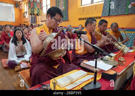Nepalese Buddhist monks play traditional instruments during a prayer service. At the Sherpa Kyidug temple in Elmhurst, Queens, New York City. Stock Photo