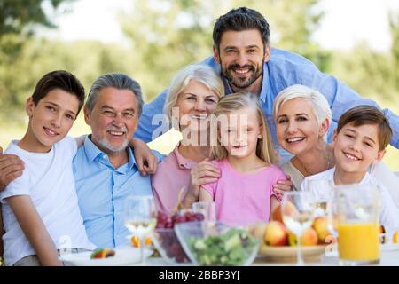 Family sitting having lunch in garden Stock Photo