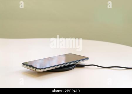 smartphone wireless charging on induction charger. Wireless charger Stock Photo