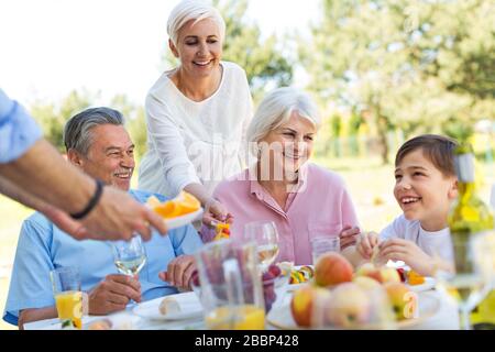 Family sitting having lunch in garden Stock Photo