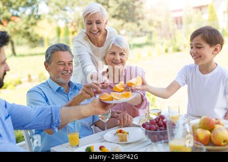 Family sitting having lunch in garden Stock Photo