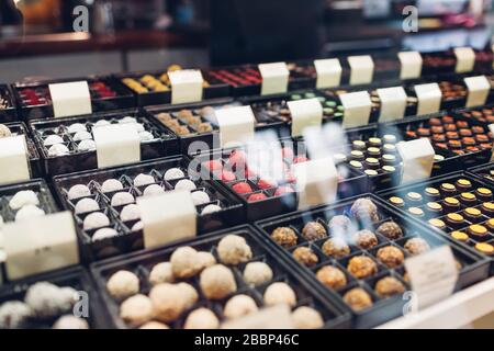 Assortment of candies desserts on cafe showcase. Variety of sweets with different flavours nuts spices in store. Stock Photo