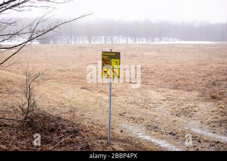 A sign indicating that hunting is allowed, while motorized vehicles, fires, and camping are not allowed in Pretty River Provincial Park. Stock Photo