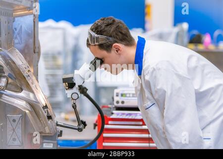 using a microscope while working in a research center Stock Photo
