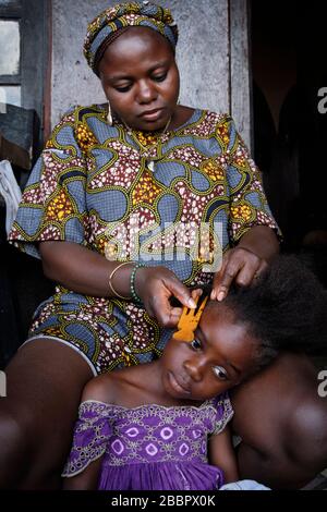 Woman combing the hair of her daughter. Stock Photo