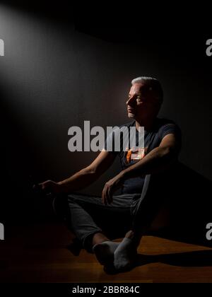 Person sitting and looking optimisticly towards light Stock Photo