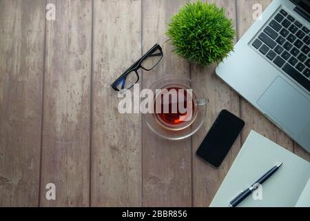 office desk table with laptop, smartphone and supplies. Top view, flat lay. Stock Photo
