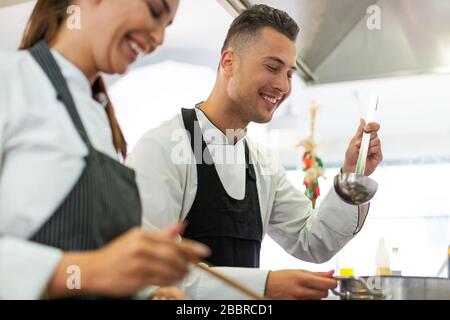 Female and male chefs in kitchen Stock Photo