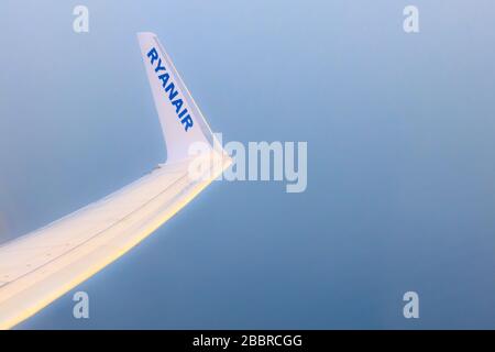Athens, Greece - April 22, 2019: Low-cost airline Ryanair logo on airplane's wing and blue sea aerial view Stock Photo
