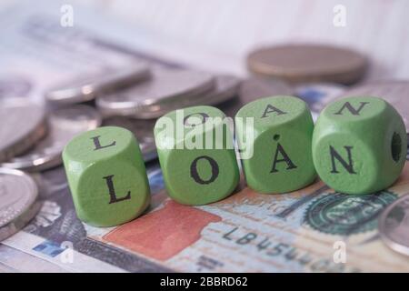 wooden cubes with black loan on wooden surface . Stock Photo