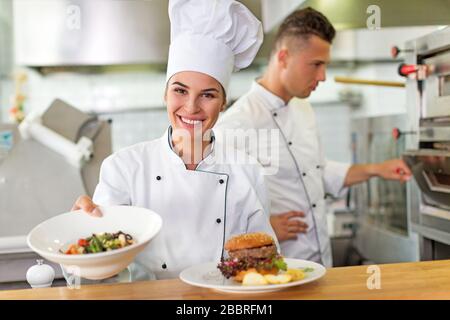 Female and male chefs in kitchen Stock Photo