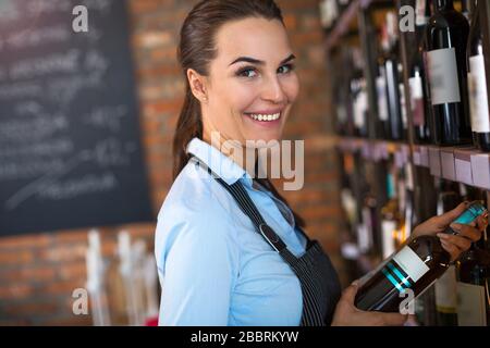 Woman working in wine shop Stock Photo