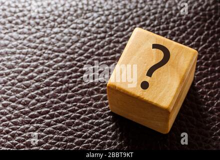 Wooden toy block with question mark on leather Stock Photo