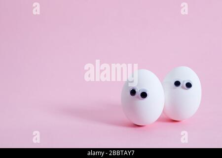 concept social networks communication and emotions - eggs wink on pink background. Copy space Stock Photo