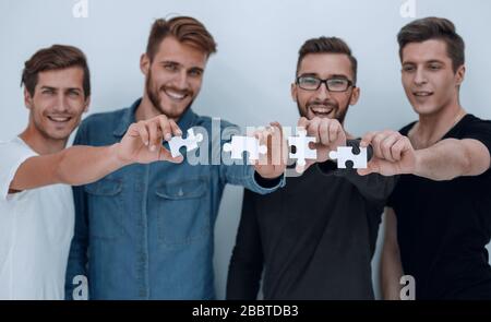 image of the guys connecting pieces of the puzzle Stock Photo