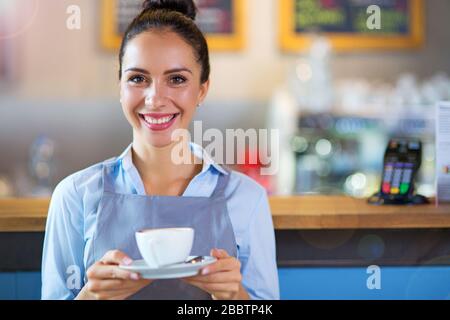 Woman working in coffee shop Stock Photo