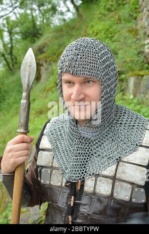 reconstruction of the medieval scene, young knight with spear and armour on guard duty Stock Photo