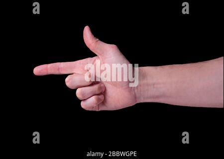 Hand of caucasian man shows the finger gun sigh on isolated black background Stock Photo