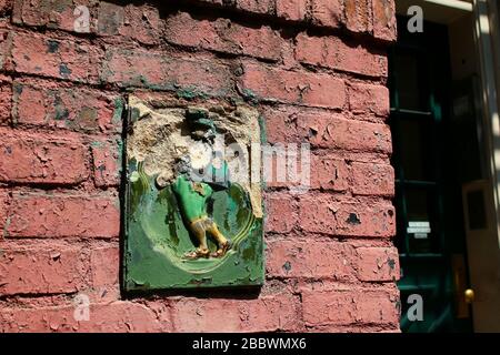 Antique glazed tile decorates brick stove next to entrance to 5 Patchin Place in Greenwich Village. Manhattan on JULY 26th, 2019 in New York, USA. (Ph Stock Photo