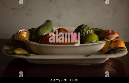 Ceramic fruit bowl and fruits seen on a table top in a London home. Stock Photo