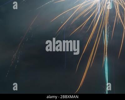 Close-up photo of a fragment of a bright colored firework similar to long ribbons against foggy sky Stock Photo