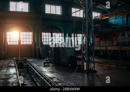 Old abandoned railroad workshop. Train repairing factory with old machinery. Stock Photo