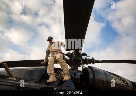 An air interdiction agent with the U.S. Customs and Border Protection, Air and Marine Operations, conducts a pre-flight check on a UH-60 Black Hawk helicopter prior to a flight in providing airspace security for Super Bowl LI, in Conroe, Texas, Feb. 1, 2017. Units with Air and Marine Operations and Office of Field Operations teamed up with the Civil Air Patrol to practice an air-to-air intercept using two AMO UH-60 Black Hawk helicopters and two C-550 Citation jets to track down a simulated incursion into restricted airspace. Stock Photo