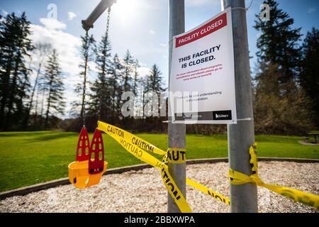 Surrey, Canada - Mar 29, 2020: Children's playground swings closed due to Coronavirus Covid-19 pandemic Stock Photo