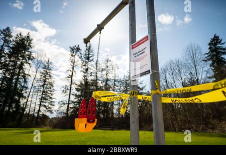 Surrey, Canada - Mar 29, 2020: Children's playground swings closed due to Coronavirus Covid-19 pandemic Stock Photo