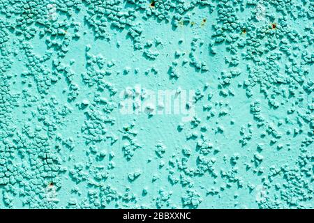 Surface of the old metal wall is covered with a lot of cracks, in which a rusty metal base is visible. Destruction of the old blue cracked paint Stock Photo