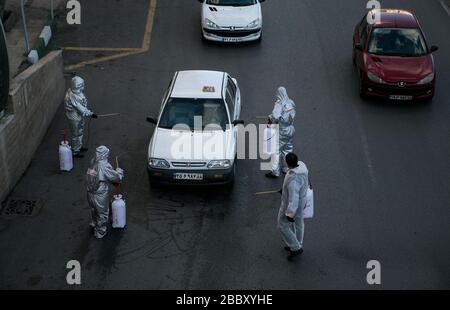 Tehran, Iran. 31st Mar, 2020. Volunteers disinfect cars on a street in Tehran, Iran, March 31, 2020. Credit: Ahmad Halabisaz/Xinhua/Alamy Live News Stock Photo