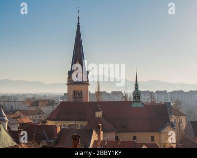 St. James church rooftop clock bell tower skyline in Ljubljana city center, Slovenia Stock Photo