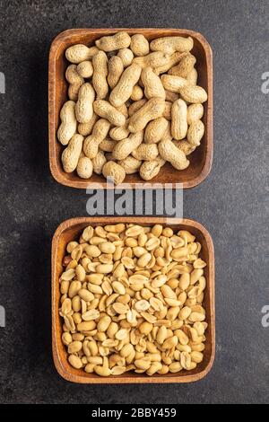 Roasted salted peanuts. Crispy nuts. Peeled and unpeeled peanuts in bowl. Top view. Stock Photo