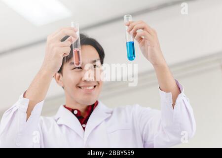 Scientist happy to successful discover new drug formula by choice select good chemical liquid in medical science lab Stock Photo