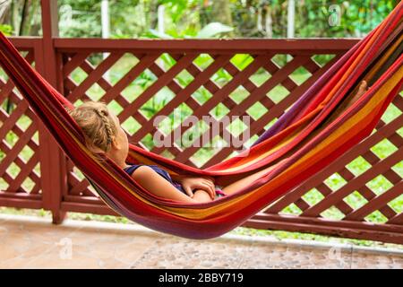 Touch child resting in a hammock at home in Puerto Viejo de Talamanca, Limon Province, Costa Rica.