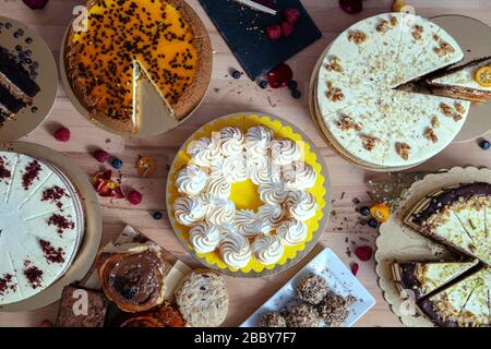 Assortment of various cakes fresh from the workshop on wooden table. Assortment of cakes for special celebrations Stock Photo