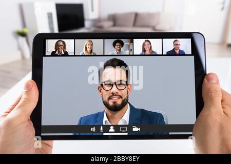 Man Working From Home Online Group Videoconference On Tablet Stock Photo