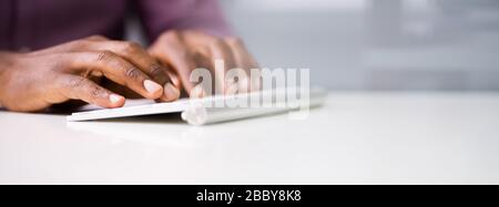 Close-up Of A Businessman Using Computer At Desk Stock Photo