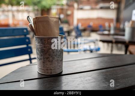 Utensil and napkin steel napkin placed on wooden picnic table in restaurant Stock Photo