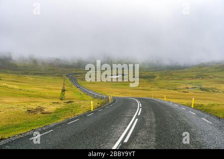 Low fog clouds over the road in high mountains in Iceland Stock Photo