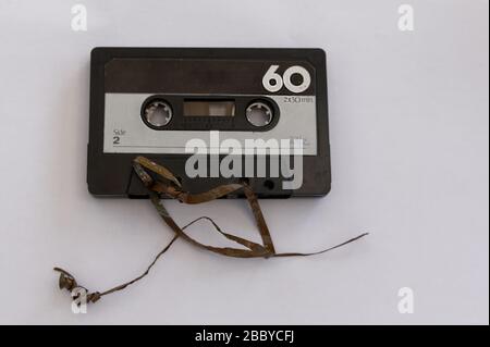 An analog magnetic tape cassette has had its tape unravelled Stock Photo