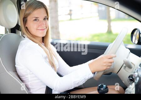Personable young woman with nice laugh is sitting in a new car Stock Photo