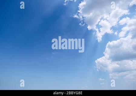 Beautiful rays of light in the sky from behind the clouds Stock Photo