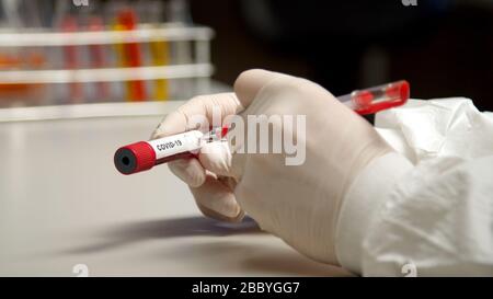 Scientist marking with pen COVID-19 test tube Stock Photo
