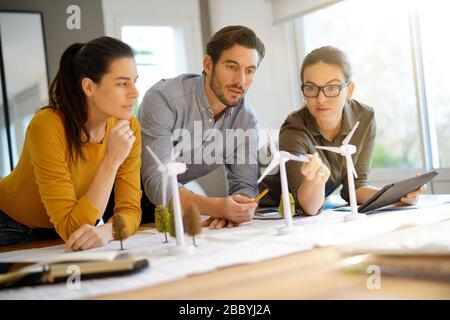 Attractive wind farm engineers looking over turbine placements Stock Photo