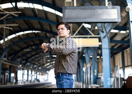 Man checking time while waiting at metro station Stock Photo