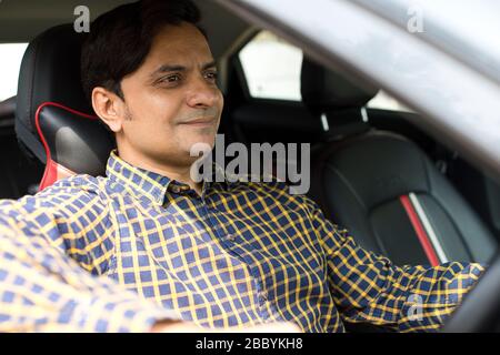 Young indian man driving car in city Stock Photo