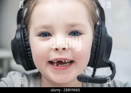 Pretty schoolgirl studying homework math during her online lesson at home, social distance during quarantine, self-isolation, online education concept Stock Photo